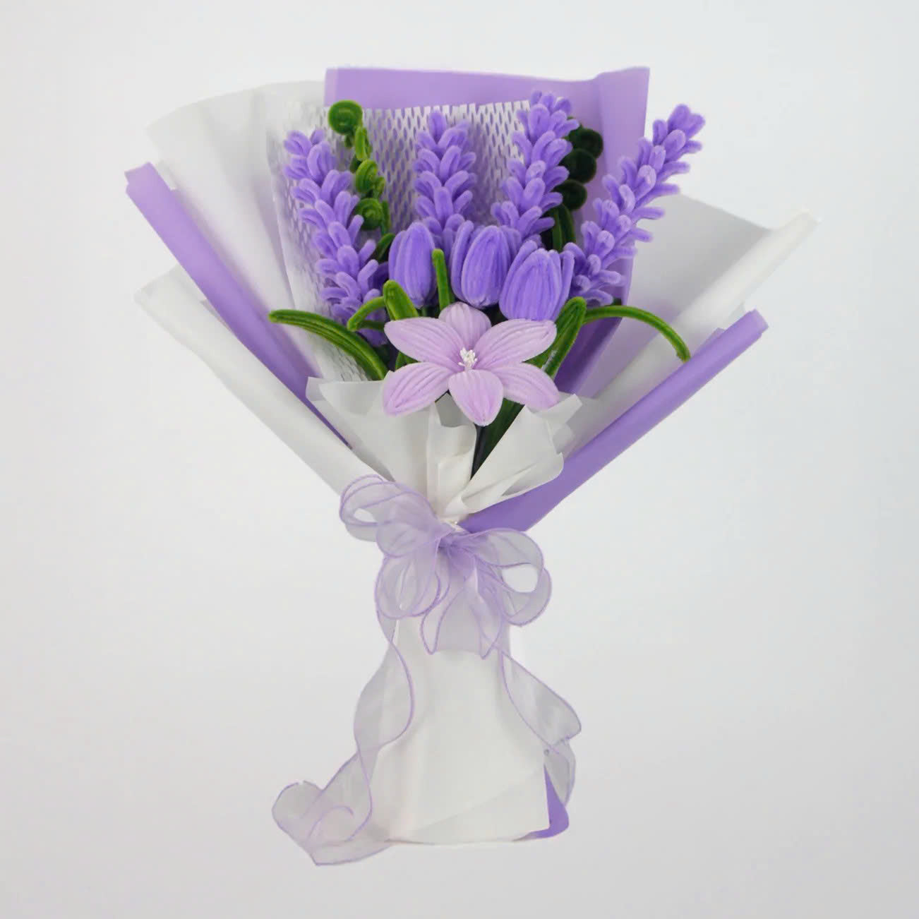 Enchanted Essence DIY bouquet featuring lavender stems, lilac tulips, and a star-shaped lily made from pipe cleaners, wrapped in layered lavender and white paper with a sheer ribbon bow.