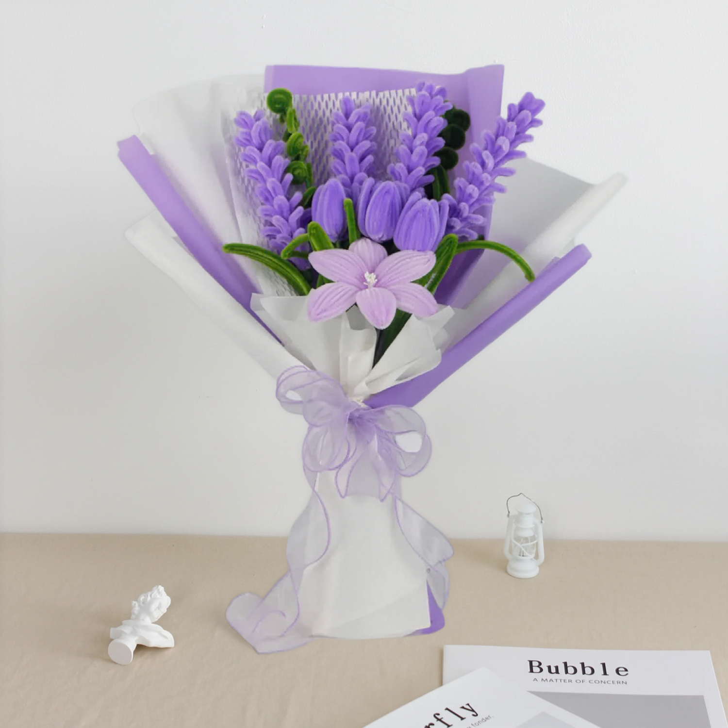 Enchanted Essence DIY bouquet featuring lavender stems, lilac tulips, and a star-shaped lily made from pipe cleaners, wrapped in layered lavender and white paper with a sheer ribbon bow.