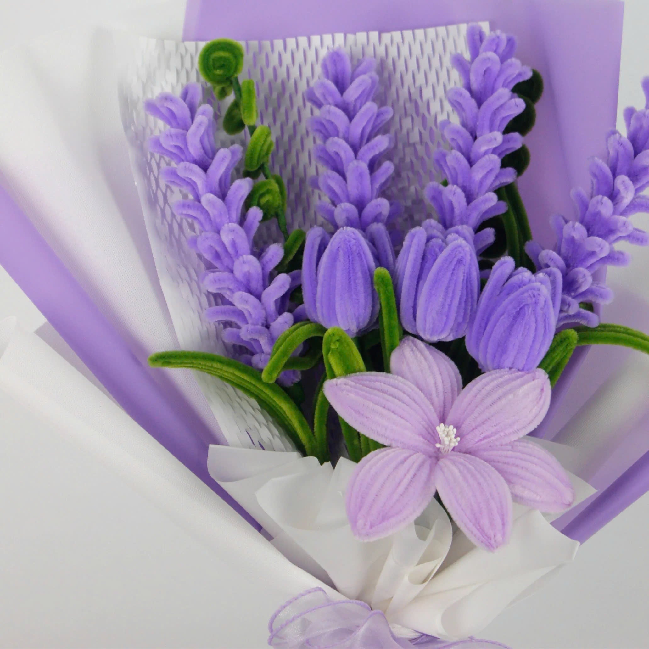 Enchanted Essence DIY bouquet featuring lavender stems, lilac tulips, and a star-shaped lily made from pipe cleaners, wrapped in layered lavender and white paper with a sheer ribbon bow.