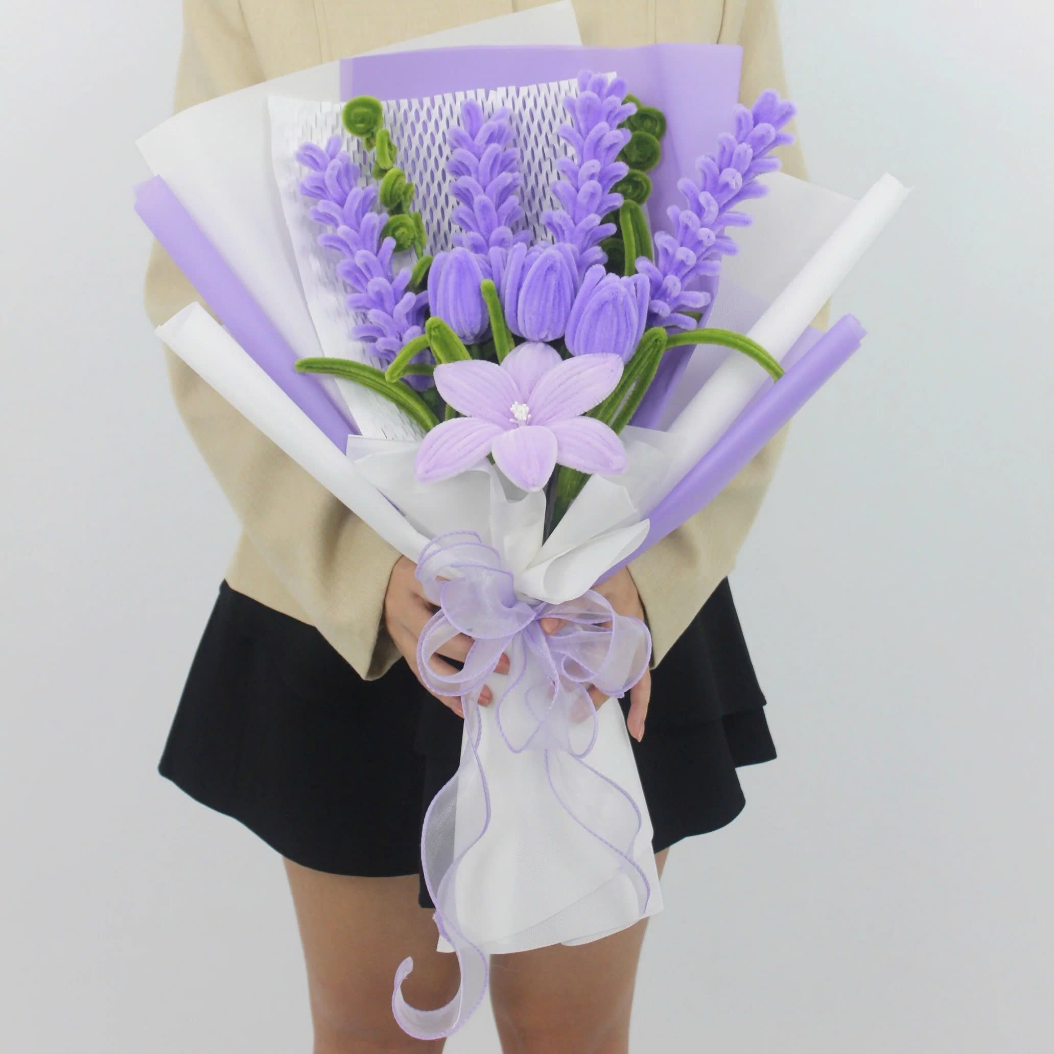 Enchanted Essence DIY bouquet featuring lavender stems, lilac tulips, and a star-shaped lily made from pipe cleaners, wrapped in layered lavender and white paper with a sheer ribbon bow.